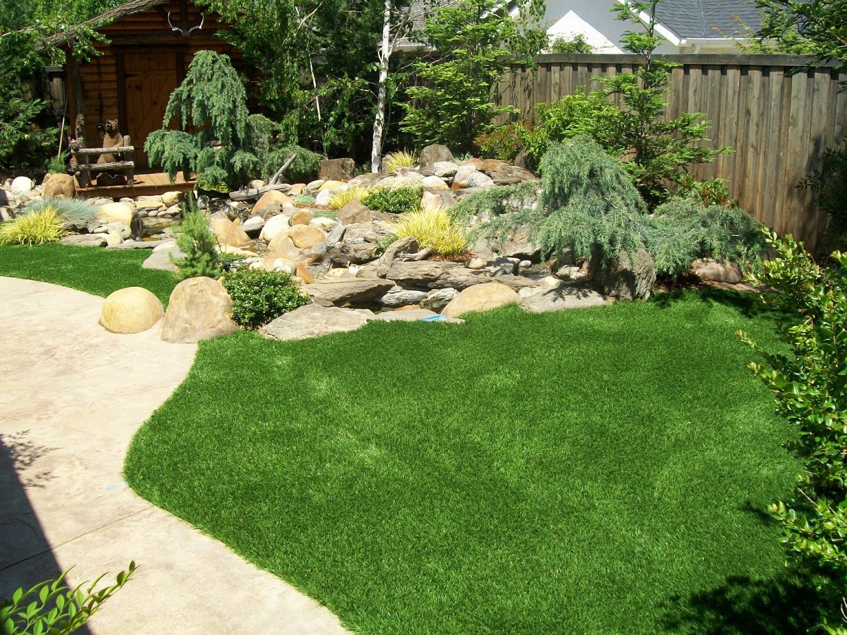 Artificial grass backyard with wooden fence